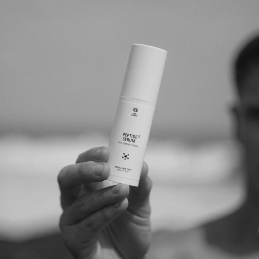 Person holding a skincare product with a blurred background